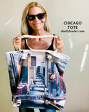 Artist Shelly Lawler holding a tote bag with Chicago River design, featuring the brand 'Shelly Lawler'.