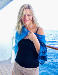 Clouds print lightweight scarf worn off one off one shoulder, showing signature pre-tied design and flowing in wind