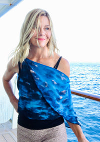 Clouds print lightweight scarf flowing in the wind on a cruise deck, showing airy movement against an ocean backdrop