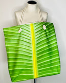 Green leaf-patterned tote bag draped over a mannequin with a white background