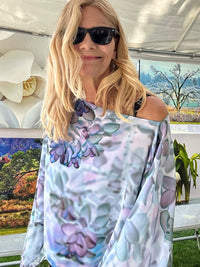 Purple and blue abstract floral poncho draped off one shoulder showing lightweight flowing fabric