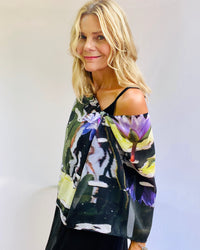 Dream scarf side view with signature pre-tied design, lightweight fabric worn off one shoulder showing waterlilies pattern 
