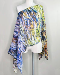 Elements Poncho displayed on a mannequin, styled over one shoulder showing lightweight flowing fabric
