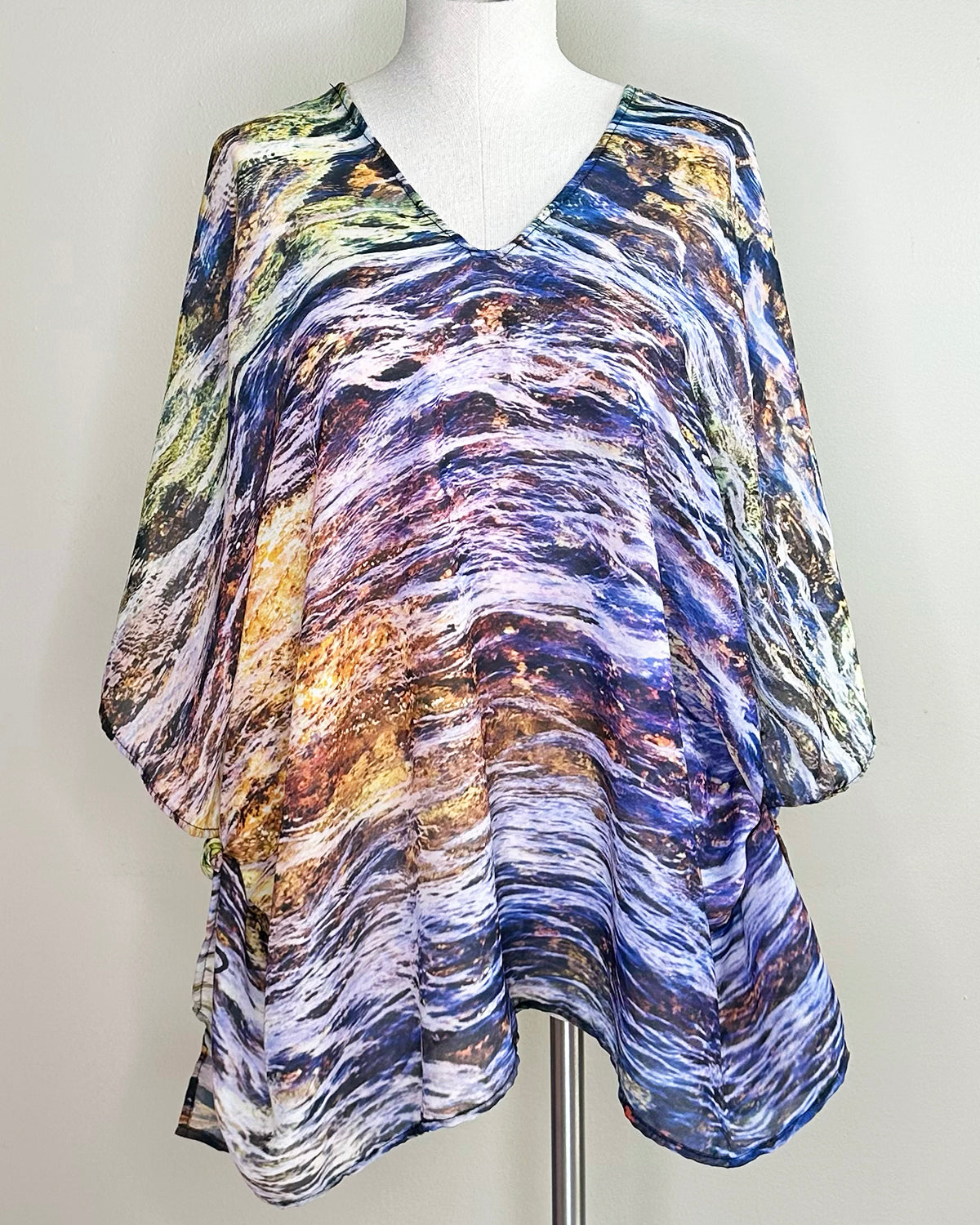 Elements Poncho displayed on a mannequin in tunic styling, showing purple jewel tones with lightweight fabric