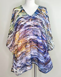 Elements Poncho displayed on a mannequin in tunic styling, showing purple jewel tones with lightweight fabric