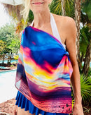 Nature-inspired scarf draped over one shoulder, showcasing vivid blue, coral, and gold sunset tones