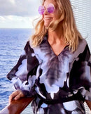 Infrared Poncho front view, slip over head design, black and white abstract art, fabric flowing in wind with ocean background
