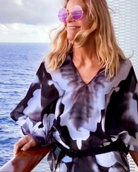 Infrared Poncho front view, slip over head design, black and white abstract art, fabric flowing in wind with ocean background
