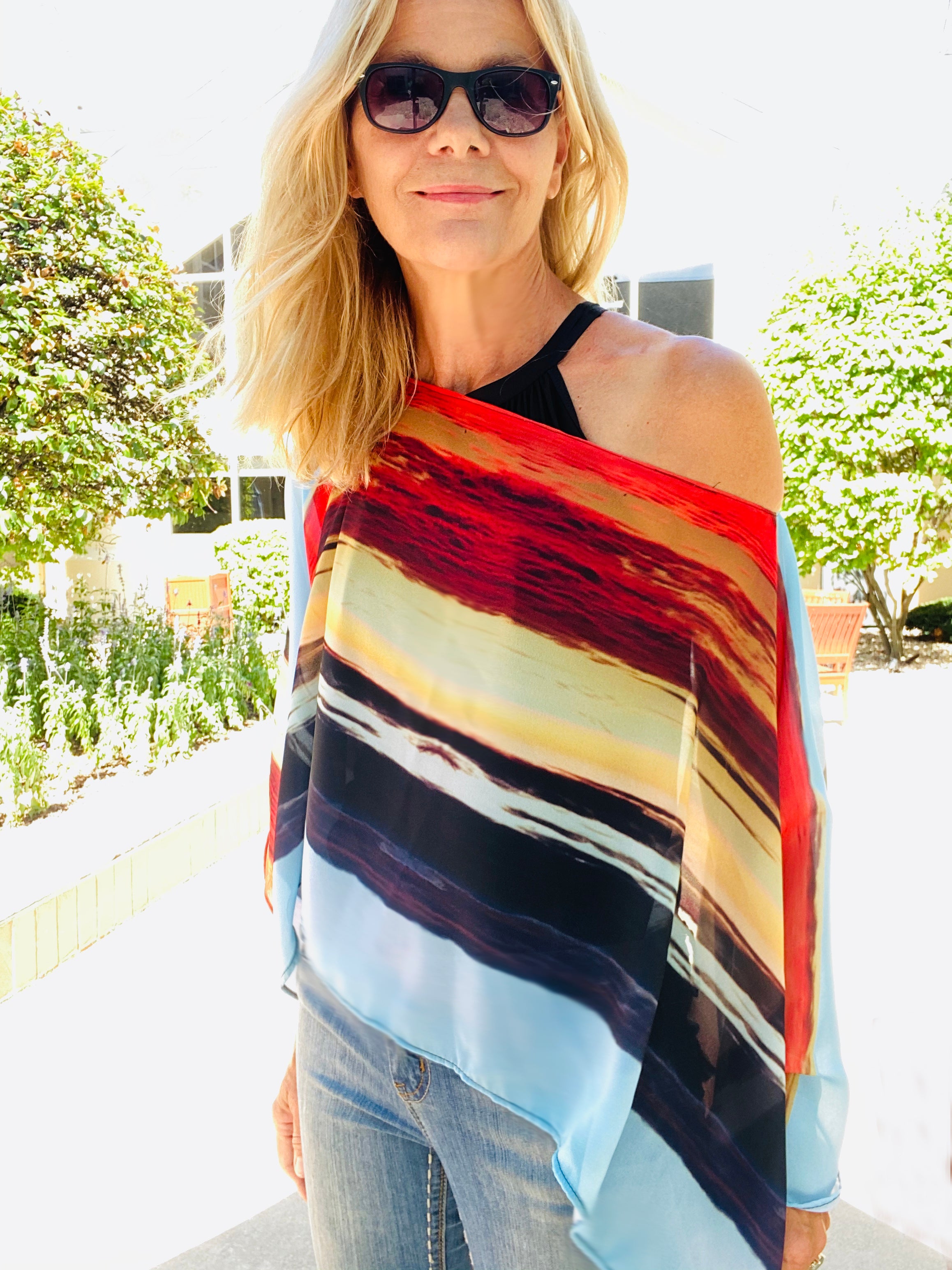 Layercake Poncho front view styled as an easy slip-over poncho, featuring bold horizontal sunset stripes and soft drape