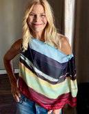 Layercake Scarf with signature pre-tied design, draped off one shoulder showing nature-inspired sunset stripe pattern on lightweight flowing fabric