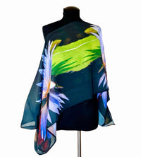 Lotus Flower Poncho front view draped off one shoulder in purple green and black floral pattern in lightweight flowing fabric