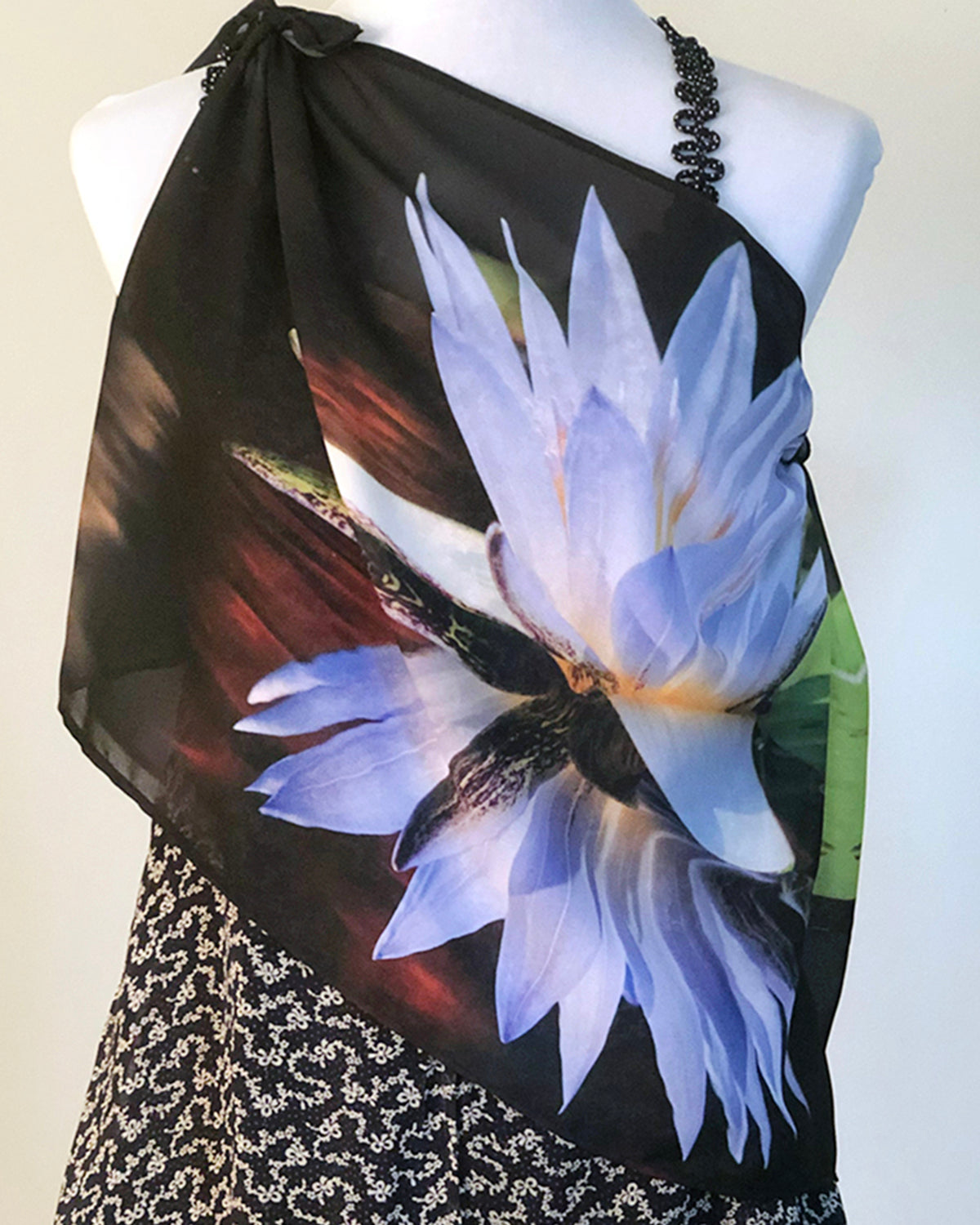 Lotus Scarf draped over the body to display lotus flower artwork layered over a patterned dress