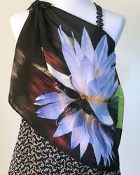 Lotus Scarf draped over the body to display lotus flower artwork layered over a patterned dress