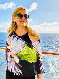 Lotus Scarf with signature pre-tied design, draped off one shoulder showing lotus flower imagery and lightweight flowing fabric