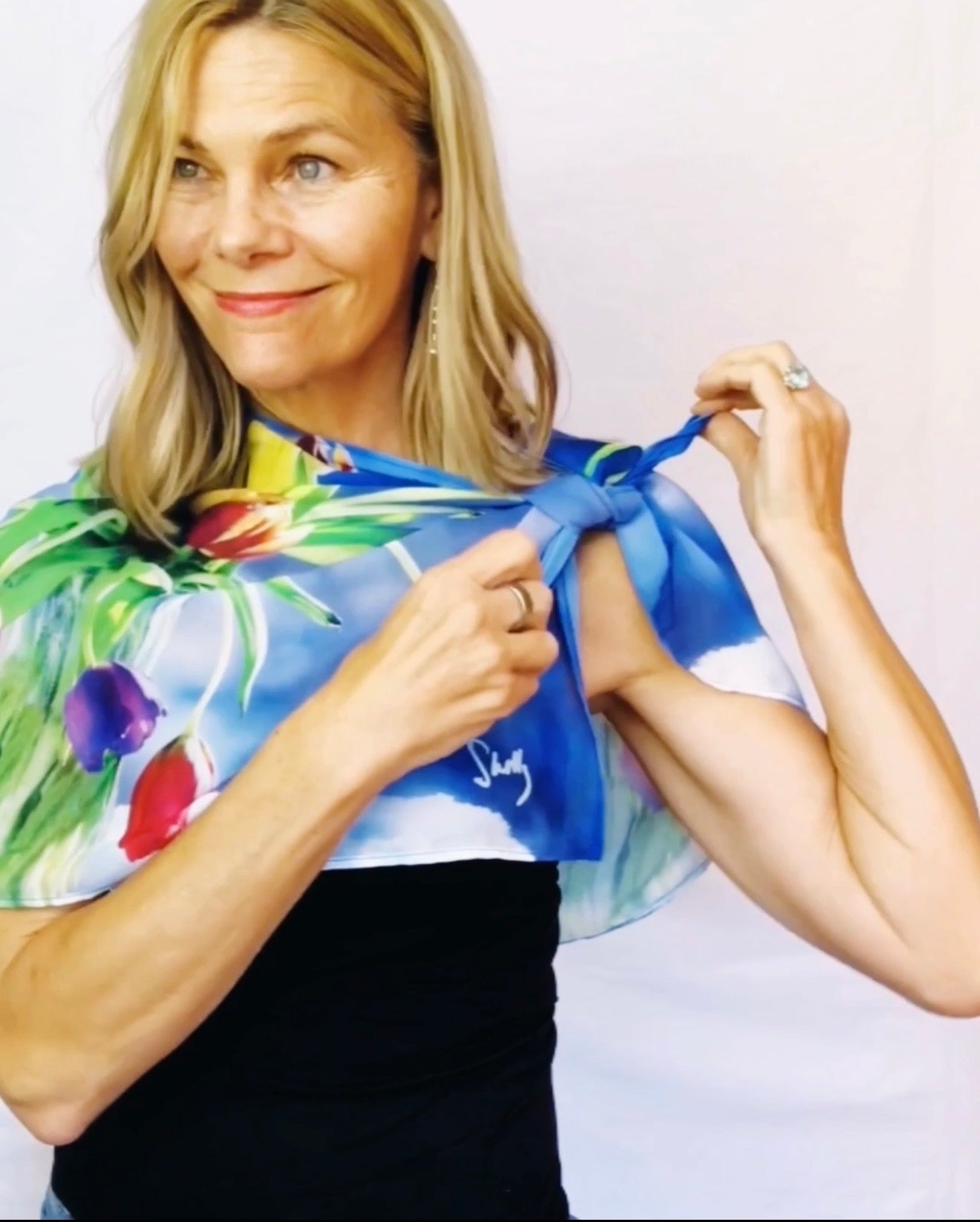 Tulips Scarf styling demonstration showing scarf slipping over shoulders with signature pre-tied design
