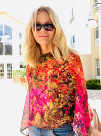 Red Poncho worn in a boatneck style, draped to show red and golden autumn artwork with lightweight flowing fabric