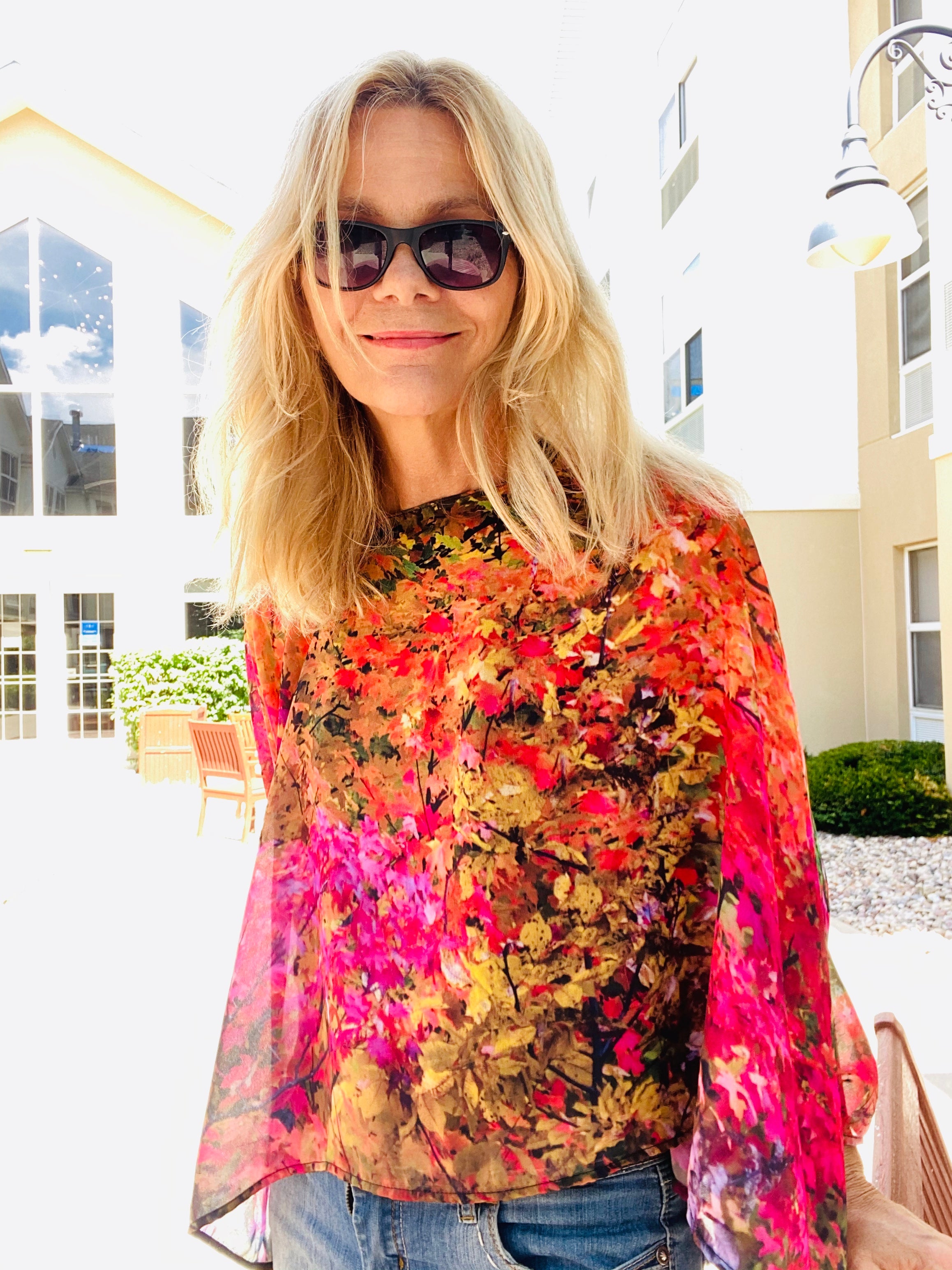 Red Poncho worn in a boatneck style, draped to show red and golden autumn artwork with lightweight flowing fabric