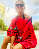 Red Rose Poncho worn off one shoulder, showing red and black rose artwork with lightweight flowing fabric