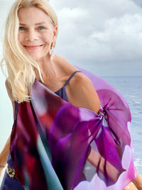 Royal Scarf draped off one shoulder, showcasing abstract floral artwork in purple and white 