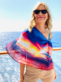 Nature-inspired scarf featuring sunset sky and ocean photography, flowing fabric in the wind
