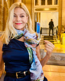 Light Years Ahead Scarf styled as an elegant neckerchief in soft blue tones worn in a Paris hotel lobby