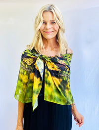 Reflection Scarf styled off shoulder showcasing abstract artwork in green, gold, and magenta with soft drape