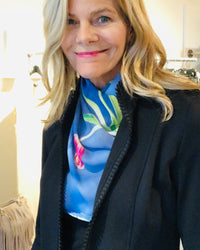 Tulips Scarf styled at the neck under a black jacket, highlighting blue tones with red tulip accents